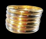 Anel com sete voltas em ouro 18k nas cores amarelo, branco e rosado. Uma das voltas partida. Med.: aro 20. Peso: 3.8g