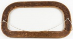Moldura dos anos 1950 de madeira em formato oval alongado com acabamento texturizado e quatro apliques decorativos em relevo floral. Med.:64x35cm.