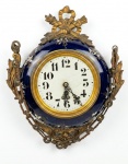 Relógio de parede em metal esmaltada azul cobalto com decoração floral em policromia e ornamentações em bronze. Observação: a máquina do relógio pode não ser original, pois o mesmo, tem mecanismo a pilha. 36 x 28 cm. Medida com a corrente: 55 cm.