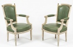Par de poltronas estilo Luís XVI em madeira com pátina provençal com revestimento em couro verde oliva e costura rebatida com tachas. 86 x 50 x 57 cm.