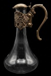 Claret jug em vidro soprado com guarniçao em metal prateado com relevo de cachos de uvas e folhas de videira. Apresenta sinais do tempo. 23 cm.
