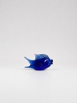 Escultura decorativa em vidro artístico modelado a quente, representando peixe de formas estilizadas, com corpo bojudo em azul-cobalto translúcido, cauda bifurcada, barbatana dorsal, nadadeiras laterais, olhos e boca aplicados. Os elementos apresentam tonalidades azuis de diferentes intensidades. Medindo: