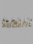 Conjunto composto por seis figuras antropomórficas de gatos músicos em porcelana moldada, esmaltada e policromada, com trajes em tons branco, amarelo e preto, realçados por filetes dourados. Representados em diferentes cenas, com violino, piano, acordeão, contrabaixo, estante e cadeira. Medindo: