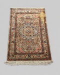 Tapete turco de Kayseri, confeccionado manualmente em seda sobre seda, apresentando campo marfim com medalhão central e densa ornamentação floral em tons de rosa, vermelho, azul, verde e bege, envolvida por múltiplas cercaduras. Provável produção da segunda metade do século XX. Medindo: 1,78 x 1,20 m. Apresenta, mancha.