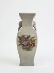 Vaso em porcelana japonesa estilo Satsuma, com esmalte craquelê, decoração floral em policromia e douração, apresentando alças laterais em forma de cabeças de elefante. Produção destinada à exportação, Japão, segunda metade do século XX. Conserva etiqueta original "Japan". Medindo 25 x 11 centímetros