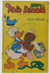 Gibi Antigo O Pato Donald Nº 1170 (1974) - Edição Especial de Páscoa - Editora AbrilApresenta marcas do tempo, dobras e sinais de manuseio nas bordas e cantos da capa. Há uma assinatura proeminente feita à caneta (nome "Rogério") no centro da capa amarela. A lombada mostra desgastes superficiais e pequenas fissuras perto dos grampos originais, típicas do papel jornal de época. Miolo e páginas internas preservados. Edição temática muito simpática e procurada por colecionadores do universo Disney.(Nota: Observe as fotos reais para avaliar as condições físicas exatas da capa).