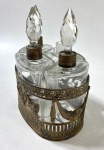Conjunto de quatro perfumeiros em cristal  com tampas lapidadas, montados sobre uma armação em bronze com rica decoração de guirlandas e cena mística. Em bom estado de conservação, falta somente uma tampa. França, século XIX. Medidas: 16x13x8cm
