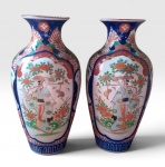 Par de grandes vasos em porcelana Imari periodo Meije (1868-1912) com rica decoração em azul, vermelho e branco, decoração ao centro de camponesas olhando ao lado, nota-se que é um par verdadeiro visto que cada uma olha para um lado oposto, 36,5cm 