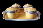 Conjunto de 4 cremeiras em porelana francesa sobre bandeja na cor amarela em estilo art deco, França cerca de 1920, pequeno bicado na parte interna em uma das cremeiras