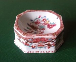 Saleiro de forma retangular com cantos chanfrados em porcelana Companhia das Índias decorada em policromia em decoração de flores, familia rosa, século XVIII, possui dois lascado na base,