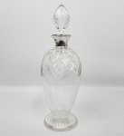 FORMIDÁVEL DECANTER PARA WISKY, BRANDY OU COGNAC EM CRISTAL COM GARGALO EM PRATA DE LEI MARCAS DA CIDADE DE BIRMINGHAM E LETRA DATA 1931. PRATEIROS JOHN THOMPSON & SONS. DE FEIÇÃO EDUARDIANA TEM CARACTERÍSTICO DESIGN ART DECO. ELABORADA LAPIDAÇÃO EM LOSANGOS FORMANDO COROA INVERTIDA SUCEDIAD POR ANÉIS CONCÊNTRICOS ATÉ A JUNÇÃO COM O GARGALO EM PRATA DE LEI. BASE COM LAPIDAÇÃO ESTRELA. INGLATERRA. 1931, 32 CM DE ALTURA