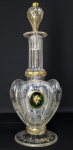 MOSER - PERIODO LUDWIG MOSER -  IMPERIO AUSTRO HUNGARO - FABULOSO DECANTER EM CRISTAL PRODUZIDO PELA CRISTALERIA MOSER NO SEGUNDO QUARTEL DO SEC. XIX. CORPO QUADRIFOBADO COM FEITIO DE TREVO.  NO BOJO CADA LOBULO TEM MEDALHÃO EM RESSALTO  NA COR ESMERALDA CONTENDO RESERVA EM OURO COM FLORES E RAMAGENS CONTENDO OS PADRÕES FLORAIS ENCONTRADOS NOS CADERNOS ORIGINAIS DO ARTIFICE  LUDWIG MOSER QUE INTEGRAM O MUSEU DA MANUFATURA. OS MEDALHÕES SÃO REALÇADOS A TODA VOLTA TAMBÉM COM OURO. O CORPO É INTEIRAMENTE GRAVADO EM RODA DE COBRE COM FLORES E RAMAGENS FINAMENTE LAPIDADAS. O GARGALO É FORMADO POR FACETAS LONGITUDINAIS JUSTAPOSTAS  EM TODO SEU COMPRIMENTO. AS FACETAS SÃO DELIMITADAS POR FRISOS EM OURO. A TAMPA MAGNIFICA FACETADA EM COLMÉIA TAMBÉM ENRIQUECIDA POR OURO. UM DECANTER PARA COLECIONADOR COM TODA EXCELÊNCIA DA PRODUÇÃO DE MOSER EM SUA ÉPOCA ÁUREA QUE A GUINDOU A POSIÇÃO DE FORNECEDOR DAS PRINCIPAIS CASAS REAIS E PRINCIPESCAS DO MUNDO. IMPÉRIO AUSTRO HUNGARO. DEC. 1870. 35 CM DE ALTURANOTA: Ludwig Moser nasceu em 1833. Ao longo da vida, dividiu-se frequentemente entre sua cidade natal, Karlovy Vary, e Viena. Foi aprendiz de gravurista com o renomado gravador de Karlovy Vary, Andrés Mattoni. Além disso, Moser aprimorou suas habilidades de desenho com o famoso pintor Ernst Anton. Em 1857, Moser decidiu abrir seu próprio negócio. Assim, nasceu a fábrica de vidro Moser. Os produtos da fábrica tornaram-se amplamente reconhecidos em toda a Europa. Não é de se admirar, pois Ludwig Moser dedicou-se integralmente à arte da fabricação de vidro. Ele não apenas supervisionava toda a produção, como também desenhava muitos dos produtos pessoalmente. Descubra os segredos das gravuras, extraídos do caderno de esboços do fundador da fábrica de vidro.