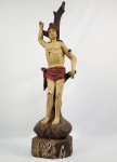 MESTRE OLIVEIRA - SÃO SEBASTIÃO -  BELA ESCULTURA  EM MADEIRA POLICROMADA. ESTRUTURA ALONGADA COM VERTICABILIDADE. O SANTO CÉ APRESENTADO NO MOMENTO DE SEU MARTÍRIO, ATADO A UMA ÁRVORE. CINGINDO CAPACETE DE LEGIONÁRIO ROMANO E VESTINDO BELO SENDAL. O ROSTO RÍGIDO E SIMÉTRICO TRANSMITE SERENIDADE SOLENE E AUSTERA. OLHOS BEM DEMARCADOS, AMENDOADOS E LIGEIRMENTE SALTADOS. OLHAR ESTATICO QUE REFORÇA O DISTANCIAMENTO MÍSTICO DA FIGURA. NARIZ FINO E RETILINIO,SEPTO NASAL ESCULPIDO DE FORMA RETA E AFILADA CONECTANDO-SE DIRETAMENTE A LINHA DAS SOBRANCELHAS OUTRA CACTERÍSTICA MARCANTE DO MESTRE OLIVEIRA. CABELOS ESCORRIDOS E COMPACTOS ESCORRENDO PARA TRÁS E LADOS DA CABEÇA. EM SINTONIA COM O RESTO DO CORPO ALONGADO, O ROSTO PODE APRESENTAR DESPROPORÇÕES DELIBERADAS EM RELAÇÃO AO TORSO PARA ENFATIZAR A EXPRESSIVIDADE ESPIRITUAL E O SOFRIMENTO ESPIRITUAL (PATHOS), DISTANCIANDO-SE DO IDEAL DE BELEZA CLÁSSICO.O QUEIXO SALIENTE. ESSE DETALHE DO QUEIXO PRONUNCIADO SERVE COMO UM EXCELENTE CRITÉRIO DE IDENTIFICAÇÃO E DIFERENCIAÇÃO AO OBSERVAR, POR EXEMPLO, OS DETALHES DAS IMAGENS SACRAS NO ACERVO DO MUSEU BOULIEU. AS MÃOS DO MESTRE SÃO UMA DE SUAS PRINCIPAIS MARCAS REGISTRADAS. OS DEDOS SÃO EXTREMAMENTE COMPRIDOS, FINOS, RETOS E COSTUMAM ESTAR DISPOSTOS DE MANEIRA RÍGIDA OU EM GESTOS COREOGRAFADOS E ELEGANTES, SEM A FLEXIBILIDADE NATURAL DAS ARTICULAÇÕES REAIS. UMA IMAGEM MUITO SEMELHANTE DO MESTRE OLIVREIRA COMPÕE O ACERVO DO MUSEU BOULIEU (VIDE EM: https://museuboulieu.org.br/museu-boulieu/s-sebastiao-9/#gid=tainacan-item-gallery-block_id-tainacan-item-attachments_id-8363&pid=1) MG, SEC. XVIII. 64 CM DE ALTURA. NOTA: O Mestre Oliveira foi um importante e enigmático santeiro e escultor do Barroco brasileiro atuante no século XVIII. Suas produções são celebradas pela erudição técnica e pela expressividade dramática típica do período colonial. Embora muitos detalhes biográficos sobre sua vida permaneçam desconhecidos pela historiografia da arte, suas obras são altamente valorizadas por colecionadores e museus de arte sacra.