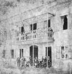 A partir desse momento apresentaremos lotes compostos pelo serviço de jantar que pertenceu a FRANCISCO NICOLAU DE LIMA NOGUEIRA DA GAMA (1862-1896),  casado com sua prima MARIANA DO LORETO DE LIMA CARNEIRO DA SILVA, filha de Manuel Carneiro da Silva, Visconde de Ururaí, neta paterna do primeiro Visconde de Araruama e bisneta do primeiro Barão de Santa Rita; sendo neta materna do Duque de Caxias. Francisco por sua vez era filho do  primeiro e único barão com grandeza de Santa Mônica, Francisco Nicolau Carneiro Nogueira da Costa e Gama, Filho de Manuel Jacinto Nogueira da Gama, Marquês de Baependi, e de D. Francisca Mônica Carneiro da Costa. Era neto materno da Baronesa de São Salvador de Campos; irmão de Brás Carneiro Nogueira da Costa e Gama, Conde de Baependi; e de Manuel Jacinto Carneiro Nogueira da Costa e Gama, Barão de Juparanã. Exerceu cargos no Paço Imperial, foi Moço Fidalgo, Fidalgo Cavaleiro, Veador, etc. Também se elegeu para cargos políticos como Deputado Provincial. Era fazendeiro e possuía a Fazenda de Santa Monica, em Valença (RJ). Casou-se com sua prima D. Luísa do Loreto Carneiro Viana de Lima e Silva (1833-1902), baronesa consorte de Santa Mônica, filha dos duques de Caxias, Luís Alves de Lima e Silva e D. Ana Luísa Carneiro Viana, sendo neta paterna do Barão da Barra Grande (Brigadeiro Francisco de Lima e Silva, membro da regência trina) e bisneta materna da Baronesa de São Salvador de Campos.  A união de FRANCISCO E MARIANA reuniu a geração das duas únicas filhas sobreviventes do DUQUE DE CAXIAS já que seu único varão faleceu tragicamente aos 14 anos vitimado por uma pneumonia. O aparelho é surpreendente pelo incomum feitio quadrado e pela requintada decoração. Com o mesmo requinte o serviço de taças de BACCARAT personalizado com a inicial do sobrenome desses aristocratas. Nas imagens ao lado vemos fotos feitas pelo fotografo Marc Freres realizadas na FAZENDA SANTA MÔNICA em  14 de fevereiro de 1881 quando lá estava hospedado o Imperador Dom Pedro II. Nesta visita o Imperador e a Imperatriz foram prestar condolências aos Barões de Santa Mônica pela morte do Duque de Caxias ocorrida ali mesmo naquela propriedade poucos meses antes da visita, que também ensejou  a inauguração da nova Igreja em Vassouras eregida com o patronado do BARÃO DE SANTA MONICA, a Igreja de Nossa Senhora do Patrocínio. As fotos ao lado foram tomadas por Mark ferrez hoje constituem um importante registro desta visita Imperial na Fazenda de Santa Mônica em 1881 e pertencem ao Instituto Moreira Salles.  Marc Ferrez acompanhou a comitiva imperial desde o Rio de Janeiro. A série das imagens que produziu  traz cartões estereoscópicos com a inscrição "Brésil au stéréoscope" na lateral esquerda e a assinatura de Marc Ferrez na lateral direita. Era o inicio da técnica de fotografia com esterioscopia que trazia tridimensionalidade ao oberservador a partir da observação com um esterioscopio. Apregoaremos um visor esteruiscópico desta época no final da sessão do segundo dia. A primeira imagem mostra a fachada da Fazenda Santa Mônica com a família e convidados do Barão de Santa Mônica e a comitiva imperial. Uma bandeira Imperial pende de mastro junto ao balcão da  sacada. Era natural para anunciar que durante aqueles dias habitavam aquela casa o Imperador Dom Pedro II e a Imperatriz Tereza Christina. Em plano principal o Barão de Santa Mônica sentado tendo ao lado os filhos varões Francisco e Manuel. Ainda no alpendre outros membros importantes do sexo masculino da aristocracia local e da comitiva imperial. No balcão da sacada bem junto a bandeira está a dona da casa Dona  Luisa do Loreto Viana de Lima e Silva, filha do Duque de Caxias e Baronesa de Santa Mônica. Outras mulheres igualmente aristocratas estão no balcão. Além disso personagens do sexo masculino talvez não tão importantes no contexto político e social dividem o espaço com as mulheres. As imagens seguintes mostram o interior da luxuosa casa sede com seus espaços destinados aos visitantes imperiais: A sala dos Imperador, A sala da Imperatriz e o quarto de toilette do imperador. Na segunda imagem vemos o vestíbulo da casa com a Baronesa de Santa Mônica e a nora que é também sua sobrinha dona Mariana Nogueira da Gama, filha dos Barões de Ururaí, neta do Duque de Caxias e casada com o primogênito do Barão de Santa Monica (homônimo do pai), Francisco Nicolau de Lima Nogueira da Costa e Gama. A Sala do Imperador, próxima imagem, mostra a luxosa mobília, retratos de família como o da Duquesa de Caxias, dona Dona Ana Luísa de Loreto Carneiro Viana Alves de Lima (1816-1874) que era ilha de Paulo Fernandes Ferreira Viana, desembargador e conselheiro de Dom João VI. Se casou em 1833 aos 16 anos de idade sem o consentimento dos pais. Inicialmente, a mãe de Ana não aprovava a união. Luísa Rosa Carneiro Leão nutria uma antipatia pelo Imperador D. Pedro I e pelos integrantes de seu batalhão desde que o imperador mandou destruir o jardim do Campo de SantAna, feito pelo seu marido, o Desembargador Paulo Fernandes Viana. A atitude do imperador provocou tanto desgosto que o pai de Ana adoeceu, vindo a falecer tempos depois. Outro motivo era o fato de que Luís Alves não vinha de família nobre e era quatorze anos mais velho que Ana. Enfim, o casamento foi aceito e a cerimônia acabou sendo feita com a presença do padre Pedro Bandeira Arouca. Boatos de jornais inimigos de Caxias circularam a falsa história de que ele havia sequestrado a própria esposa Ana Luísa. Na lua-de-mel, Ana Luísa propôs que Luís deixasse o Exército para viverem sem ausências repentinas. A esposa temia que as campanhas afastassem o marido de casa por muito tempo. Quando Luís partia para entregar ao Ministro da Guerra seu requerimento de dispensa, sua esposa voltou atrás e o incentivou a seguir a carreira. Respeitada na corte Imperial, a Duquesa de Caxias era descrita como uma dama piedosa e de nervos frágeis que tinha gosto pela poesia. Nas inúmeras guerras que seu marido lutou fazia a contribuição que podia, ajudando as viúvas e órfãos dos militares mortos na Guerra do Paraguai e na Construção do Asilo dos Inválidos da Pátria na Ilha do Bom Jesus. Caxias tratava a esposa por meu bem, minha idolatrada mulher, minha querida duquesa, minha duquesa e Anica, como a chamava o esposo, inconsolável viúvo depois de 1874. As duas filhas eram chamadas de Anicota e Aniquinha. O único filho morreu aos 14 anos. Seu pai o chamava de cadete, cadete Luisinho e Luisinho. Entre os familiares, Duque de Caxias era tratado como Luís. Em 23 de março de 1874 falecia a mais ilustre fidalga do Império e seu viúvo, o marechal glorioso, escrevia a um amigo: Perdi o maior bem que eu tinha neste mundo".  AS salas seguintes são a Sala da Imperatriz e o Toilette do Imperador.