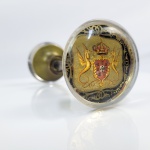 BRASIL COLÔNIA  HISTÓRICA MAÇANETA COM PEGAS EM CRISTAL DECORADAS COM O BRASÃO REAL PORTUGUÊS ADOTADO A PARTIR DE 1760. OS SUPORTES SÃO DUAS SERPES ALADAS EM OURO QUE GUARNECEM O ESCUDO DE ARMAS REAL ENCIMADO POR COROA. FOI ADOTADO PELO REI DOM JOSÉ I (VIDE NOS CREDITOS EXTRAS A REPRESENTAÇAO DO ESCUDO INSTITUIDO POR DOM JOSÉ I E AMPLAMENTE UTILIZADO POR SEUS SCUESSORES NO TRONO). PELA TRADIÇÃO ORAL ESTA MAÇANETA FOI RETIRADA DE UM DOS PRÉDIOS/PALACIOS DO GOVERNO COLONIAL QUANDO DA INDEPENDÊNCIA DO BRASIL EM 1822. FRANÇA, INICIO DO SEC. XIX. 13 CM DE COMPRIMENTO.NOTA: Em meados do sec. XVIII surgiram as maçanetas com pega em cristal, modeladas inicialmente na Inglaterra e França. Eram peças muito raras destinadas somente a palácios e residências da nobreza. A partir do ano de 1800 tornaram-se mais frequentes durante os períodos da regência e império francês.  Ainda eram entretanto caras sendo montadas com guarnição em bronze como é o caso desta em pregão. O brasão aplicado sob o cristal mostra ser esta maçaneta um elaborado produto de encomenda para uma residência  ou prédio de governo que certamente eram frequentados pelo Rei.