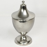 DOM PEDRO II  PAÇO IMPERIAL DE SÃO CRISTÓVÃO   JOALHEIRO IMPERIAL CHARLES MARIN O MESMO ARTIFICE DA COROA E DA ESPADA CERIMONIAL DE DOM PEDRO II.  SUNTUOSA COMPOTIER EM PRATA DE LEI COM MARCAS DE CONTRASTE DO PRATEIRO CHARLES MARIM (CM) JOALHEIRO E ARTÍFICE  DA CASA IMPERIAL BRASILEIRA  ATIVO ENTRE 1840 E 1880. DESIGN LIMPO COM CURVAS GRACIOSAS APRESENTA EM RESERVA NO BOJO O MONOGRAMA PII SOB COROA IMPERIAL.  INTERIOR E FUNDO DA BASE COM TRABALHO MARTELADO. PEÇAS DE CHARLES MARIM COMO ESTA OFERTADA NESTE LOTE COMPÕE O ACERVO DO MUSEU IMPERIAL DE PETRÓPOLIS (VIDE EM: https://www.tempocomposto.com.br/descricao.php?id_cad_imagem=4215&kw=petr%F3polis&horizontal=1&vertical=1&page=13) CHARLES MARIM TAMBÉM FOI O ARTIFICE DA COROA DE DOM PEDRO II E DA ESPADA CERIMONIAL DO IMPERADOR. O DESIGN DA COROA PERMITE SUPOR QUE ESTA FOI UMA DAS PEÇAS ENCOMENDADAS NO INICIO DA DECADA DE 1840 POR OCASIÃO DA COROAÇÃO DE DOM PEDRO II MAS TAMBÉM PARA O PROVIMENTO E REMODELAÇÃO DOS SERVIÇOS DE ALFAIS E BAIXELAS DO PAÇO DE SÃO CRISTÓVÃO. COMPOTAS DE FIGO ERAM O DOCE PREDILETO DO IMPERADOR DOM PEDRO II E É PERTAMENTE SUPOR QUE DESTA COMPOTEIRA LHE FORAM SERVIDAS. BRASIL, DEC. 1840. 24 CM DE ALTURA. 625 GNOTA: Dom Pedro II tinha hábitos alimentares simples, mas adorava doces regionais brasileiros e receitas clássicas. Entre suas sobremesas favoritas destacavam-se o pudim de gabinete, doce de figo em calda, sorvete de pitanga, e a famosa goiabada cascão. O doce de figo em calda era presença constante nas refeições do monarca. Era comum que ele degustasse a fruta cozida na calda de açúcar e especiarias acompanhada de queijo minas frescal, uma combinação clássica apreciada até os dias de hoje. Durante uma de suas viagens a Minas Gerais, especificamente na região da Serra do Caraça, o imperador provou e encantou-se com o pudim de gabinete. O doce curioso recebia este nome porque era guardado em um armário chamado "gabinete" para conservação, já que não havia geladeira na época. Ele leva ingredientes como biscoito champanhe, frutas cristalizadas, passas, doce de banana, mamão e goiabada, tudo ligado por uma massa de ovos e leite. RECEITA DE PUDIM DE GABINETE: O pudim de gabinete é uma sobremesa histórica que remonta ao século XIX, muito apreciada na corte brasileira da época, incluindo por Dom Pedro II. Trata-se de uma iguaria em que camadas de pão de ló ou biscoitos intercalam-se com frutas cristalizadas, secas e frescas, cobertas por um creme de ovos e assadas em banho-maria.Ingredientes Históricos e de Montagem A receita tradicional utiliza ingredientes clássicos das despensas do século XIX: 20 a 25 unidades de biscoito tipo champanhe100g de uvas passas (brancas e pretas)100g de frutas cristalizadas picadas100g de ameixas secas sem caroço picadasFrutas frescas da época (como fatias de maçã, banana nanica ou pêssegos em calda)Manteiga e açúcar refinado para untar a formaRaspas de 1 limão (para aromatizar) Creme Base6 ovos grandes500 ml de leite integral400 ml de calca grossa de açúcar e gema (hoje em dia substituída por uma lata de leite condensado)Modo de Preparo1.Preparar a Forma: Unte generosamente uma forma de pudim (com furo no meio) usando manteiga e polvilhe com açúcar.2.Montar as Camadas: No fundo e nas laterais da forma, faça uma "cama" com os biscoitos champanhe. Adicione camadas intercaladas com as uvas passas, ameixas, frutas cristalizadas e as frutas frescas. 3.Fazer o Creme: No liquidificador, bata o leite, os ovos, o leite condensado (ou o açúcar, se preferir a versão 100% rústica) e as raspas de limão até formar um creme homogêneo. 4.Despejar: Despeje este líquido delicadamente sobre as camadas de biscoitos e frutas na forma. 5.Assar: Cubra a forma firmemente com papel-alumínio. Asse em banho-maria em forno preaquecido a 180C por aproximadamente 1 hora e 30 minutos a 2 horas (o tempo varia dependendo do forno). 6.Esfriar e Servir: Retire do forno, deixe esfriar e por pelo menos 2 horas antes de desenformar. Era um pudim que era guardado em armário mas hoje em dia pode-se servir gelado