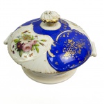 DOM PEDRO II  - MAIS TARDE PERTENCEU AO BARÃO DE ITACURUÇÁ (MANOEL MIGUEL MARTINS O GRANDE ARREMATANTE DOS LEILÕES IMPERIAIS APÓS A PROCLAMAÇÃO DA REPÚBLICA). MAGNIFICA TERRINA COM TAMPA EM PORCELANA  (TEM O PAR APREGOADO NO LOTE ANTERIOR) COM EXUBERANTE TOM EM AZUL REMATADO EM OURO COM CACHOS DE UVAS E PARRAS. PALMÁCEAS RELEVADAS COMPLETAM A DECORAÇÃO. LUXURIANTE DECORAÇÃO FLORAL EM ESMALTE. MARCAS DA CASA COMERCIAL B WALLERSTEIN & CIA IMPORTADORA DO RIO DE JANEIRO. ESSE SERVIÇO HÁ MUITO TEMPO TEM SIDO ALVO DE DISCUSSÕES SOBRE A TITULARIDADE DO ENCOMENDANTE INICIAL. ISSO PROQUE A DECORAÇÃO É IDÊNTICA AO SERVIÇO DE CAÇA DE DOM PEDRO II. ENTRETANTO EM ESTUDO RECENTE CHEGOU-SE AOS ASPECTOS QUE FAZEM REIVINDICAR AO IMPERADOR PEDRO II E SEU SERVIÇO DE CAÇA TAMBÉM ESSE SERVIÇO QUE PERTENCEU POSTERIORMENTE AO BARÃO DE ITACURAÇÁ ADQUIDIRO NO LEILÃO DOS PAÇOS IMPERIAIS. SENÃO VEJAMOS: A MARCA DO IMPORTADOR SOB A LOUÇA É DA CASA COMERCIAL B WALLERSTEIN & CIA IMPORTADORA DO RIO DE JANEIRO NAS RUA DO OUVIDOR, FORNECEDORES DA CASA IMPERIAL E IDENTICA A MARCA DA LOUÇA DO SERVIÇO DE GALA DE DOM PEDRO I. BERNANDO WALLERSTEIN ESTABELECEU-SE NA RUA DO OUVIDOR AINDA EM 1828, SOB O NOME DE WALLERSTEIN & CIA, DURANTE O PRIMEIRO IMPÉRIO APÓS DESVINCULAR-SE DA P SAISSET & CIA COM QUEM TINHA SOCIEDADE. AINDA NA DÉCADA DE 1840, QUANDO O BARÃO DE ITACURUÇÁ SEQUER TINHA NASCIDO MUDOU SUA RAZÃO SOCIAL PARA B. WALLERSTEIN E M. MASSET PORTANTO ESSA LOUÇA FOI CERTAMENTE ENCOMENDADA NA DECADA DE 1840 NUNCA PELO BARÃO DE ITACURUÇÁ QUE VEIO AO MUNDO DEPOIS QUE A IMPORTADURA ABANDONOU A MARCA SOB A BASE. O FATO DA DECORAÇÃO SER IDÊNTICA A DO SERVIÇO IMPERIAL DE CAÇA TAMBÉM REFORÇA A UNIDADE DO APARELHO. O LIVRO DA MORDOMIA DO PAÇO DE SÃO CRISTÓVÃO RELATA VÁRIAS ENCOMENDAS DE PORCELANA FEITAS A CASA DE BERNARDO WALLERSTEIN NA DECADA DE 1840: 192$500 A BERNARDO WALLTERSTEIN E CIA., POR QUINHENTOS E DEZESSEIS PRATOS DE PORCELANA FINA 5:132$736 A BERNARDO WALLERSTEIN, POR NOVE DÚZIAS E QUATRO CASAIS DE XÍCARAS DE PORCELANA FINA DOURADA 373$330: A WALLERSTEIN, LOUÇA DE PORCELANA FINA 927$000 A B. WALLERSTEIN, POR QUATRO CAIXAS COM LOUÇA DE PORCELANA FINA 4:848$000 . FINALMENTE O BARÃO DE ITACURUÇÁ COMO GRANDE ARREMATANTE DOS LEILÕES DO PAÇO APÓS A PROCLAMAÇÃO DA REPÚBLICA ADQUIRIU DENTRE OUTRAS PRECIOSIDADES TODO O SERVIÇO DE PORCELANA DO CASAMENTO DE D. PEDRO I E D. AMÉLIA DE LEUCHTEMBURG ERA UM APRECIADOR DE PORCELANAS IMPERIAIS. SEGUNDO O ANÚARIO DO MUSEU IMPERIAL DE PETRÓPÓLIS PUBLICADO EM 1944 OS CATÁLOGO DO QUARTO E SEXTO LEILÕES DO PAÇO DE SÃO CRISTÓVÃO EM 1890 TRAZEM DESCRITOS COMO LOTE 838 A SEGUINTE DESCRIÇÃO: - 1 SOBERBO SERVIÇO DE FINA PORCELANA FRANCESA, ESMALTE AZUL, OURO, E FINAS PINTURAS, COM 568 PEÇAS PARA JANTAR. ESTÁ AÍ A DESCRIÇÃO DO SERVIÇO IMPERIAL MUITO PROVAVELMENTE ARREMATADO PELO BARÃO DE ITACURUÇÁ. AINDA O LOTE 857 TRAZ A SEGUINTE DESCRIÇÃO: 857 - 1 RIQUÍSSIMO SERVIÇO DE FINÍSSIMA PORCELANA DE SÈVRES COM PRIMOROSAS PINTURAS A ESMALTE E ARMAÇÃO DE BRONZE DOURADO A FOGO, 17 PEÇAS EM VITRINE (PRESENTE DE NAPOLEÃO III À IMPERATRIZ DONA TERESA CRISTINA. ENTÃO O LOTE 857 É O APARELHO PRESENTEADO POR NAPOLEÃO III AOS IMPERADORES E NÃO O DO LOTE NUMERO 838 QUE QUASE INDUBITAVELMENTE É O SERVIÇO ADQUIRIDO PELO BARÃO DE ITACURUÇÁ. REPRODUZIDO NA PAGINA 274 DO LIVRO LOUÇA DA ARISTOCRACIA NO BRASIL DE JENNY DREYFUS E NA PAGINA 44 DO LIVRO LOUÇA HISTÓRICA MUSEU DE ARTE DA BAHIA. FRANÇA, 26 CM DE DIAMETRONOTA: Manoel Miguel Martins Barão de Itacurussá, nasceu em10 de novembro de 1831 em Sant'Ana do Itacurusá e faleceu em 01 de janeiro de 1911, filho deJoão Martins e de Gertrudes Margarida. Casou em09 de março de 1867, no Rio de Janeiro, com Jerônyma Eliza de Mesquita, Baronesa de Itacurusá nascida em02 de junho de1851 no Rio de Janeiro/RJ e batizada na Igreja de Santa Rita, e falecida em 24 de setembro de 1917, filha de Jerônymo José de Mesquita Conde de Mesquita e de Elisa Maria de Amorim. Casaram-se em 09 de março de 1867 (portanto Jerônima estava com 16 anos de idade) na Igreja de S. Francisco Xavier. Título nobiliárquico de Barão de Itacurussá outorgado , em 25 de março de 1888, a Manuel Miguel Martins era um título de origem toponímica. Ilha e povoação do Estado do Rio de Janeiro, lugar de onde era natural este titular. Foi um homem riquíssimo, proprietário de terras e capitalista do Rio de Janeiro. Sua esposa a baronesa Jerônima Elisa de Mesquita Martins, era filha do conde de Mesquita e neta do marquês de Bomfim. O Barão foi o grande comprador do Leilão do Paço Imperial, onde além de muitas preciosidades, adquiriu todo o serviço de porcelana do casamento de D. Pedro I e D. Amélia de Leuchtemburg.