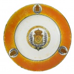 BRASIL IMPÉRIO  RARO PRATO DO CORPO POLICIAL DO RIO DE JANEIRO. SALÃO DE BANQUETES DO OFICIALATO.  LINDO PRATO EM LOUÇA COM ABA DECORADO COM LARGO BARRADO EM LARANJA COM TRÊS RESERVAS CIRCULARES CONTENDO O BRASÃO IMPERIAL; AO CENTRO, BRASÃO IMPERIAL EM RESERVA CIRCUNDADO POR UMA JARRETEIRA COM A LEGENDA CORPO POLICIAL DA PROVÍNCIA DO RIO DE JANEIRO - NICTEHRÓY 1º DE MARÇO DE 1888; NO REVERSO MARCA ANTHONY SHAW & SONS. AQUELE PERÍODO, A CIDADE DE NITERÓI FUNCIONAVA COMO A CAPITAL DA PROVÍNCIA DO RIO DE JANEIRO (ENQUANTO O MUNICÍPIO DO RIO DE JANEIRO ERA O MUNICÍPIO NEUTRO, SEDE DA CORTE IMPERIAL). POR ISSO, AS GRANDES DECISÕES E COMEMORAÇÕES DA FORÇA POLICIAL FLUMINENSE OCORRIAM EM TERRITÓRIO NITEROIENSE. ESSE SERVIÇO DE LOUÇA FOI PRODUZIDO NO CONTEXTO DA ARISTOCRACIA IMPERIAL BRASILEIRA DO FINAL DO SÉCULO XIX, ENCOMENDADO ESPECIFICAMENTE PARA CELEBRAR OU SERVIR À ALTA OFICIALIDADE DO CORPO POLICIAL DA PROVÍNCIA DO RIO DE JANEIRO EM SUA SEDE, NA CIDADE DE NITERÓI.  EXEMPLAR DO MESMO SERVIÇO REPRODUZIDO À PÁGINA 227 DO LIVRO LOUÇA DA ARISTOCRACIA NO BRASIL, POR JENNY DREYFUS. INGLATERRA, SÉC. XIX. 23 CM DE DIÂMETRO.NOTA:  Durante o Império, a alta oficialidade da polícia fluminense fazia parte da aristocracia, o que explica a ostentação de encomendar louças de luxo brasonadas da Inglaterra, como os pratos de Niterói de 1888.  Era responsável por manter a lei e a ordem na província. O fato histórico mais importante e de maior projeção nacional com a participação direta do Corpo Policial da Província do Rio de Janeiro foi a sua atuação na Guerra do Paraguai (18641870). Em 1865, atendendo ao chamado do Império do Brasil, a corporação fluminense enviou um contingente de 510 homens para o front de batalha. Sob o comando do tenente-coronel João José de Brito, a tropa policial foi incorporada ao Exército Imperial e rebatizada oficialmente como o 12º Corpo de Voluntários da Pátria. A participação direta da corporação nesse conflito gerou impactos históricos profundos. No campo de batalha, os policiais fluminenses destacaram-se pelo extremo denodo, bravura e forte impacto de suas investidas contra as linhas inimigas. Essa agressividade tática e coragem nos combates rendeu à tropa o apelido célebre de "Treme-Terra", uma alcunha que atravessou os séculos e ainda hoje é orgulhosamente lembrada na tradição histórica da atual PMERJ.  O 12º Corpo de Voluntários da Pátria atuou de forma decisiva na expulsão das tropas paraguaias de territórios ocupados na Argentina e participou de importantes incursões logísticas e táticas ao longo da campanha da Tríplice Aliança..