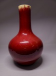 LANG YAO  PRECIOSO  FLOREIRO DE FEITIO BULBOSO DITO VASO GARRAFA (BOTTLE VASE)  CONSTRUÍDO EM PORCELANA DITA  LANG COM ESMALTE VERMELHO UNDERGLAZE - SANG DE BOEUF. DINASTIA QING, REINADO QIANLONG. NA TRADIÇÃO CHINESA ESTE  FORMATO É CHAMADO PNGBAOPING. NO CONTEXTO DA CHINA ESTÁ FORTEMENTE ASSOCIADO À GARRAFA DE ÁGUA PURA DE GUANYIN  UM VASO RITUALÍSTICO DE CERÂMICA OU PORCELANA CHINESA MUITO UTILIZADO COMO ARTIGO DECORATIVO E EM TEMPLOS BUDISTAS. NA TRADIÇÃO E ICONOGRAFIA ORIENTAL, A DEUSA DA COMPAIXÃO GUANYIN É FREQUENTEMENTE REPRESENTADA SEGURANDO ESTE VASO SAGRADO EM FORMATO DE REDOMA/GARRAFA, USADO PARA ESPALHAR ÁGUA DIVINA E ABENÇOADA PARA PURIFICAR O MUNDO E ALIVIAR O SOFRIMENTO. MAGNÍFICA COMPOSIÇÃO DE CORES OBTIDAS COM QUEIMA CONTROLADA. A BORDA TEM O DESEJÁVEL EFEITO CONHECIDO TECNICAMENTE COMO BORDA DE OSSO (DENGCAOBIAN). ESSE EFEITO NÃO É UMA PINTURA, MAS SIM UM RESULTADO NATURAL E MUITO VALORIZADO DO PROCESSO DE QUEIMA DO ESMALTE SANGUE DE BOI. O ESMALTE VERMELHO À BASE DE COBRE É EXTREMAMENTE DENSO E FICA MUITO FLUIDO QUANDO ATINGE ALTAS TEMPERATURAS DENTRO DO FORNO IMPERIAL. DURANTE A QUEIMA, O ESMALTE DERRETIDO ESCORRE SUAVEMENTE DO TOPO EM DIREÇÃO À BASE DO VASO.  AO ESCORRER, A CAMADA VERMELHA FICA EXTREMAMENTE FINA NA BORDA SUPERIOR (O LÁBIO DO VASO), PERMITINDO QUE A COR BRANCA NATURAL DA PORCELANA OU DO ESMALTE DE FUNDO APAREÇA ATRAVÉS DELA.EM PEÇAS AUTÊNTICAS E VALIOSAS DAS DINASTIAS QING E SUBSEQUENTES, A PRESENÇA DESSA TRANSIÇÃO SUAVE E GRADUAL PARA UMA BORDA CLARA E LEVEMENTE CRAQUELADA É CONSIDERADA UMA ASSINATURA DE ALTA QUALIDADE TÉCNICA E CONTROLE DO FORNO. CHINA, SEGUNDA METADE DO SEC. XVIII. 38 X 24 CM.NOTA: LANG TINGJI, foi nomeado pelo Imperador KANGXI, supervisor de porcelana nos fornos de Jingdezhen. A intenção do Imperador era a de recriar as famosas porcelanas monocromáticas do período Ming do SEC. XIV. Os chineses tem essa particularidade, um respeitoso culto aos ancestrais e suas conquistas. Edmund de Waal em seu livro O Caminho da Porcelana: A jornada de Uma Obsessão (recomendo muitíssimo) referencia assim essa respeitosa paixão pela memória dos ancestrais: Esse pode ser o ano em que alguém encomenda a fabricação de turíbulos que se parecem muito com os turíbulos feitos há trezentos anos. Esses por sua vez foram feitos para aludir bronzes de 900 anos atrás. Assim a devoção atravessa os séculos e as gerações. LANG TINGJI era extremamente dedicado e mergulhou fundo na tarefa que lhe foi destinada. O problema é que o pigmento de vermelho intenso que dá o tradicional aspecto vidrado dessas porcelanas conhecidas no mundo ocidental como sang de boeuf (sangue de boi) era feito a base de coral e ágata o que o tornava extremamente caro. O próprio fabrico era delicado, principalmente quanto ao processo de queima e a porcelana que LANG TINGJI finalmente conseguiu reproduzir, tinha uma margem de perda muito grande e passou a ser conhecida como 100 para 1 (a cada 100 peças somente uma era aproveitada). Mas esse custo não desmotivou o imperador KANGXI afinal ele era o grande imperador iniciador da dinastia QING. Ele era um homem 100 para 1. Tamanho era esse custo de produção que gerou um ditado sobre a porcelana de LANG como ficou então conhecida, em homenagem a seu redescobridor: Quer ficar pobre? Faça porcelana de Lang. Hoje nós conhecemos essa produção como LANG YAO. AINDA SOBRE O FORMATO DESTE MAGNIFICO VASO: A história desse formato remonta a milênios na arte oriental, carregando um forte significado espiritual e prático. As silhuetas que inspiraram o vaso garrafa surgiram na China arcaica antes da Dinastia Shang (16001045 a.C.). Inicialmente modelados em bronze ritualístico ou barro, os vasos conhecidos como Hu apresentavam essa mesma transição fluida: uma base bojuda imitando uma pera e um gargalo mais estreito. Eles eram usados originalmente para armazenar e servir vinho em rituais sagrados. A Evolução para o Sagrado (Yuhuchunping) Durante a Dinastia Tang (618907 d.C.), o formato evoluiu para o modelo clássico Yuhuchunping (Vaso em formato de pera) nos templos budistas. Ele era utilizado especificamente para conter água pura, simbolizando a limpeza espiritual e a cura. Com o tempo, nas dinastias Song e Yuan, o design passou a ser adotado pela nobreza como uma peça puramente decorativa de altíssimo status. O Apogeu Imperial no Século XVIIIO formato de garrafa atingiu sua perfeição técnica na Dinastia Qing, especialmente durante o reinado do Imperador Kangxi (16621722). Foi neste exato período que os artesãos dos fornos imperiais de Jingdezhen conseguiram dominar o instável esmalte Sangue de Boi (Langyao hong). Unir a silhueta clássica da garrafa com o vermelho profundo e brilhante tornou-se o auge da sofisticação da porcelana imperial.