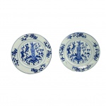 REINADO KANGXI  PAR DE PRATOS (DE UMA SEGUENCIA EM QUE FORAM  APRESENTADOS DOIS DO MESMO CONJUNTO NO LOTE ANTERIOR E MAIS DOIS NO LOTE A SEGUIR) EM PORCELANA CHINESA DO PERÍDO KANGXI (16621722)  DECORADOS EM ESMALTES AZUIS UNDERGLAZE.  UMA DAS ERAS DE MAIOR PRESTÍGIO E QUALIDADE NA HISTÓRICA DA PORCELANA AZUL E BRANCA DA CHJINA. COM DECORAÇÃO FLUIDA E ELEGANTE TEM NA ABA REMOS CONINUOS E SINUOSOS QUE SE ESTENDEM AO LONGO DE TODA A CIRCUNFERÊNCIA. ESSES RAMOS ALTERNAM ENTRE FOLHAS LANCEOLADAS DETALHADAS E BOTÕES DE FLORES ESTILIZADOS. NA TRADIÇÃO DA PORCLEANA CHINESA ESSES ARRANJOS DE TREPADEIRAS E FLORES NA BORDA NÃO SÃO MERAMENTE ESTÉTICOS, REMETEM A IDEIA DE CONTINUIDADE, LONGEVIDADE E RENOVAÇÃO CONSTANTE. A CALDEIRA É DECORADA EM PADRÃO BOGU QUE SIMBOLIZA VOTOS DE REFINAMENTO E BOA FORTUNA. ESTÃO NA CALDEIRA UM VASO CENTRAL QUE REMETE AS 100 ANTIGUIDADES, POUSADO SOBRE UM SUPORTE QUADRADO CLÁSSICO. O VASO É DECORADO COM ARRANJOS FLORAIS INDICANDO REFINAMENTO ACADÊMICO. FITAS FLUIDAS DITAS RIBBONS ENVOLVEM A MESA E O VASO ESSAS FITAS ESTÃO SEMPRE PRESENTES QUANDO SE APRESENTAM OS OBJETOS PRECIOSOS QUE INTEGRAM AS 100 ANTIGUIDADES. POSTERIORMENTE AOS VASOS ESTÁ UM TABULEIRO COM PADRÃO QUADRICULADO QUE REPRESENTA O JOGO MILENAR WEIGI UM DOS QUATRO TALENTOS ESSENCIAIS EXIGIDOS DE UM ERUDITO CHINÊS TRADICIONAL.  DELIMITANDO A CALDEIRA DA BORDA DUAS MOLDURAS DE LINHAS CONCÊNTRICAS DUPLAS. RARAMENTE SE ENCONTRARÃO DISPONÍVEIS SETS DE PORCELANA KANGXI COMO ESTE COM SEIS PRATOS  DE UM MESMO PADRÃO. CHINA, FINAL DO SEC. XVII OU INICIO DO XVIII. 23 CM DE DIAMETRONOTA:  Há 800 anos Marco Polo, trouxe da China para o ocidente a primeira peça de porcelana, um pequeno jarro verde acinzentado que está até hoje no tesouro da Basílica de São Marco em Veneza. Essa foi a semente da obsessão da Europa pelo Ouro Branco. No crepúsculo da DINASTIA MING, chegou à China em 1698 o Padre Jesuíta François Xavier d'Entrecolles. O declínio Ming sobreveio de uma crise causada pela corrupção, a exploração da classe dominante e desastres naturais durante anos sucessivos. Os rebeldes começaram a tomar o poder em algumas regiões e a dinastia chegou ao seu oficial fim com o suicídio do último imperador, Weizong. O poder passou então a nascente Dinastia Qing, que por 250 anos governou a China e sobre seu domínio a produção da porcelana Companhia das Indias atingiu seu apogeu em beleza e volume. Estima-se que 60 milhões de peças de porcelana foram exportadas para Europa nesse período. O Imperador QIANLONG governou o país por quase todo o sec. XVIII. Pouco antes do inicio desse grande reinado, ainda sob o período KANGSHI chegou a China o Padre DEntrecolles. Veio para salvar almas dos pagãos mas teve a sua própria alma arrebatada pela obsessão da porcelana. O ouro branco, encantou os europeus desde o primeiro leilão fruto da carga apreendida pelos holandeses de dois navios Portuguses. Era tão alto o preço da porcelana da China que um aparelho de jantar custava o equivalente ao valor de um pequeno palácio. Foi então que na Europa começou a busca da fórmula da composição e do processo para fabricação da porcelana. A princípio, julgaram que era feita a partir de conchas e casca de ovos moídos e tentaram reproduzir o efeito com esses matérias. Claro, tudo em vão porque a porcelana nada tinha a ver com esses elementos. O primeiro Imperador da Dinastia Qing foi Kangxi e este deu ordens de esconder, sob pena de morte, o processo de fabricação. O Padre DEntrecolles valeu-se dos chineses convertidos de Jingdezhen para descobrir aos poucos o processo. Um dia finalmente ele descobriu o segredo mais importante para obtenção da porcelana, em uma região remota chamada KAO-LING (COLINA ELEVADA) os chineses extraiam há séculos a argila chamada caulim que era o principal elemento constituinte da louça da China. O resto, as proporções, o modo de fazer, de decorar e a queima ele cuidou em aprender gradativamente. Em 1712 o Padre DEntrecolles escreveu para França relatando suas descobertas e descrevendo em minúcias o processo de fabricação. Dessa forma um segredo milenar foi revelado a Europa ensandecida pela porcelana e sua capacidade de trazer riquezas além de qualquer sonho aos homens. Paralelamente na Europa, Augusto II, chamado O FORTE, aprisionou em seu castelo um jovem aprendiz chamado BOTTEGER, que se gabava de ser alquimista, e o ameaçou de pena de morte se não conseguisse desvendar o processo para a fabricação. Cinco anos BOTTEGER esteve preso realizando experimentos sistemáticos até chegar por seu próprio mérito à fórmula da porcelana. Embora não tenha sido um método muito ortodoxo, funcionou. Surgiu a manufatura de Meissen. Nessa mesma época na China, LANG TINGJI, foi nomeado pelo Imperador KANGXI, supervisor de porcelana nos fornos de Jingdezhen. A intenção do Imperador era a de recriar as famosas porcelanas monocromáticas do período Ming do SEC. XIV. Os chineses tem essa particularidade, um respeitoso culto aos ancestrais e suas conquistas. Edmund de Waal em seu livro O Caminho da Porcelana: A jornada de Uma Obsessão (recomendo muitíssimo) referencia assim essa respeitosa paixão pela memória dos ancestrais: Esse pode ser o ano em que alguém encomenda a fabricação de turíbulos que se parecem muito com os turíbulos feitos há trezentos anos. Esses por sua vez foram feitos para aludir bronzes de 900 anos atrás. Assim a devoção atravessa os séculos e as gerações. A porcelana chinesa antiga ainda traz encantamento por sua beleza, sua coloração branca azulada e a magnífica decoração. Não por acaso, cada peça de porcelana Companhia das Índias que nos chega à mão é tratada com reverência e devoção não apenas por ser fruto do trabalho do oleiro que lhe deu forma e a decorou, mas por ser produto de 5000 anos de uma cultura extraordinária e única. AS CEM ANTIGUIDADES O PRINCIPIO DAS COISAS:As "Cem Antiguidades" (Baigu ou Po-ku) é um famoso tema decorativo da arte chinesa que reúne emblemas de boa sorte, sabedoria e erudição, refletindo os ideais da classe letrada tradicional. O motivo não representa exatamente cem objetos literais, mas sim uma rica coleção de itens associados à cultura, ao estudo e à filosofia na China antiga. Das cem antiguidades se originaram tudo que existe no mundo. Objetos de Estudo: Pincéis, blocos de tinta, papel e pedras de amolar tinta (os quatro tesouros do letrado).Artes e Passatempos: Instrumentos musicais, tabuleiros de xadrez chinês, livros e rolos de pintura ou caligrafia. Rituais e Símbolos: Vasos de bronze arcaicos, queimadores de incenso, cetros ruy de prosperidade e recipientes rituais que homenageiam os antepassados. Esse repertório visual consolidou-se fortemente durante a dinastia Qing (16441911) e era aplicado em porcelanas, pinturas e painéis. Demonstra a busca por virtude, refinamento intelectual e o respeito contínuo aos ancestrais. Cada objeto funciona como um símbolo ou enigma visual que deseja vida longa, paz, felicidade e riqueza para o lar. 