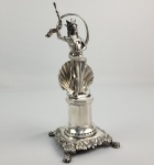 PALITEIRO ANFRITITE - MAGNÍFICO PALITEIRO DE MESA DE BANQUETE  EM PRATA DE LEI. ANFRITITE É APRESENTADA COROADA, EMPUNHANDO CETRO E POSICIONADA A FRENTE DE UMA CONCHA DE VIEIRA SUTENTADA POR UM PEDESTAL EM FACETAS COM BASE APRESENTANDO ORNAMENTOS FLORAIS ,ASSENTE SOBRE PÉS DE GARRA. MARCAS DE CONTRASTE P COROADO (CIDADE DO PORTO)  DO FINAL DO SEC. XVIII OU INICIO DO XIXE PRATERIO DA MESMA ÉPOCA REFERENCIADO POR MOITINHO COMO P464. ESSE PALITEIRO FAZ PARTE DA SÉRIE SURGIDA NO INÍCIO DO SEC. XIX COM PERSONAGENS MITOLÓGICOS E SÃO EXTREMAMENTE COLECIONÁVEIS NO BRASIL E EM PORTUGAL. PORTUGAL, SEC. XVIII OU INICIO DO XIX.21  CM DE ALTURA.