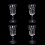 BACCARAT POLIGNAC   COM SELO DA MANUFATURA  IDENTICAS AS APRESENTADAS NO LOTE ANTERIOR .ORIGINALMENTE ENCOMENDA DO GOVERNO FRANCÊS (PRESIDENTE RENÉ COTY) PARA O BANQUETE OFICIAL OFERECIDO EM HOMENAGEM A RAINHA ELIZABETH II NA GALERIA DOS ESPLEHOS DO PALÁCIO DE VERSALHES EM 9 DE ABRIL DE 1957. RÉGIO CONJUNTO COM QUATRO TAÇAS PARA ÁGUA EM CRISTAL DO MODELO POLIGNAC DA BACCARAT. APRESENTA LAPIDAÇÕES VERTICAIS ESPESSAS E PROFUNDAS (ORGUE BEVEL CUTS) QUE SAEM DA HASTE E SOBEM PELO BOJO. O DETALHAMENTO GEOMÉTRICO CRIA UM VISUAL ROBUSTO QUE SIMULA UM CÁLICE MODERNO, CONTRASTANDO COM A SUAVIDADE DA BORDA SUPERIOR LISA. FOI BATIZADO EM HOMENAGEM À DUQUESA DE POLIGNAC, FIGURA HISTÓRICA CONHECIDA POR SEU GOSTO REFINADO E PROXIMIDADE COM A RAINHA MARIA ANTONIETA. FRANÇA, DEC. 1950. 16 CM DE ALTURA.NOTA: O modelo foi criado exclusivamente para servir a Rainha Elizabeth II e o Príncipe Philip em sua visita oficial à França em 1957. Ele decorou a mesa do banquete na Galeria dos Espelhos no Palácio de Versalhes. O presidente francês René Coty encomendou o design para impressionar a monarca com a modernidade do cristal francês. Seus cortes verticais profundos funcionam como prismas que refletem a luz das velas, criando um brilho único na mesa. Cada taça exigia o trabalho de vários artesãos altamente qualificados, conhecidos como Meilleurs Ouvriers de France.do: Devido à lapidação profunda, as taças são notavelmente mais pesadas que os modelos tradicionais. O nome celebra a Duquesa de Polignac, que foi a amiga mais íntima e favorita da rainha Maria Antonieta. As peças produzidas antes de 1936 não tinham logotipo gravado, mas como o Polignac nasceu nos anos 1950, todas as peças originais trazem a marca circular jateada da Baccarat na base.