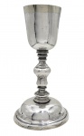 SINGULAR CÁLICE LITÚRGICO EM PRATA DE LEI BATIDA SETECENTISTA. DE EXCEPCIONAL FEITIO. A BORDA E O INTERIOR TEM RESQUICIOS DE VERMEIL. O ELEGANTE FUSTE É APRESENTADO EM BALAÚSTRE. A BASE DE DIAMETRO AVANTAJADO E CHATO CONFERE ELEGÂNICA E DISTINÇÃO. BRASIL, SEC. XVIII. 23 CM DE ALTURA. 400 G
