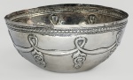 RARA FARINHEIRA EM PRATA DE LEI ESTILO E ÉPOCA DONA MARIA I  BATIDA E REPUXADA. CORPO DECORADO COM ELABORADA FAIXA COMPOSTA POR GUIRLANDA COM FESTÕES E FLORES PENDENTES.  BORDA COM PEROLADO. POR SER UM OBJETO DE USO DIÁRIO, QUE ACABAVAM SENDO DANIFICADAS PELO USO CONTÍNUO É UMA RARIDADE ENCONTRA-LAS EM NOSSOS DIAS. PEÇA DIGNA DE MUSEU. BRASIL, SEC. XVIII. 17 CM DE DIAMETRO POR 8 CM DE ALTURA.NOTA: No Brasil colonial a farinha de mandioca era a base da alimentação de todas as classes, dos escravos aos senhoras. Serví-la em um recipiente de prata ricamente trabalhado era a forma que a aristocracia encontrou para demonstrar extrema riqueza através de um hábito cotidiano simples e para distinguir o consumo de uma um alimento universal por uma classe abastada. Típicamente brasileiras, as farinheiras, as primeiras farinheiras eram feitas com cascas de coco-da-baía ou de porongos cortados ao meio. Quando os ourives começaram a fabricar as versões em prata de lei, eles mantiveram o formato semicircular, bojudo e sem alças, imitando perfeitamente o formato do coco original. prata era valorizada na época não apenas pela beleza, mas também porque se sabia que ela ajudava a conservar os alimentos por mais tempo. Em um clima tropical e sem refrigeração, o uso da prata impedia a proliferação rápida de fungos e carunchos na farinha.