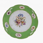 DUQUE DE CAXIAS RARÍSSIMO PRATO RASO EM PORCELANA PERTENCENTE AO SERVIÇO DO DUQUE DE CAXIAS, LUIZ ALVES DE LIMA E SILVA UM DOS QUATRO DUQUES BRASILEIROS (O ÚNICO SEM SANGUE REAL) . ABA NA TONALIDADE VERDE COM RESERVAS FLORAIS PINTADAS MANUALMENTE. ARREMATES EM OURO. CALDEIRA COM EXUBERANTE RESERVA FLORAL. ESSE SERVIÇO FOI APREGOADO EM LEILÃO EM 1928 ADQUIRIDO PELO COLECIONADOR INACIO AREAL REALIZADO PELO LEILOEIRO DA ÉPOCA, BASTOS DIAS. DEPOIS EM 1983 FOI LEILOADO POR FERNANDO SOARES EM SÃO PAULO ESSA PEÇA EM PREGÃO TAMBÉM ESTÁ REPRODUZIDA NO CATÁLOGO DO LEILÃO REFERIDO ACIMA (O DE FERNANDO SOARES) E FOI REPRODUZIDA EM MATÉRIA DA DÉCADA DE 90 SOBRE INVESTIMENTO EM MERCADO DE ARTES (VIDE FOTOS DA MATÉRIA E DO CATÁLOGO DO LEILÃO). PEÇA DESSE APARELHO ESTA REPRODUZIDA A PÁGINA 209 DO LIVRO LOUÇA DA ARISTOCRACIA DO BRASIL POR JENNY DREYFUS. FRANÇA, SEC. XIX. 26,5 CM DE DIAMETRO NOTA: Luís Alves de Lima e Silva (25/8/1803-7/5/1880) nasce em Vila do Porto da Estrela, em uma família de militares. É declarado cadete aos 5 anos. Em 1823, com apenas 20 anos, participa da campanha pelo reconhecimento da independência na Bahia como tenente. Promovido a capitão, conduz a linha de frente brasileira na Guerra da Cisplatina em 1825. É nomeado major e chefia o batalhão do imperador até 1831. Em 1840 combate os focos de resistência ao governo central no Maranhão e no Piauí. Em recompensa pela pacificação das duas províncias, é elevado ao posto de brigadeiro e recebe o título de barão de Caxias. Como comandante das Armas da Corte, reprime a Revolução Liberal de 1842 em São Paulo e em Minas Gerais e dirige as tropas imperiais contra a Revolta dos Farrapos. Em 1845, dom Pedro II o indica para o Senado pelo Rio Grande do Sul. Lidera as tropas do Exército nas guerras platinas em 1851 e exerce, depois, a Presidência da província gaúcha. Em 1866 chefia as forças brasileiras na Guerra do Paraguai e conquista Assunção em 1869. No mesmo ano recebe o título de duque de Caxias. Morre na cidade de Barão de Juparanã, no Rio de Janeiro. Duque de Caxias (Luís Alves de Lima e Silva) (1803-1880) foi um militar brasileiro. É o Patrono do Exército. Foi um dos maiores vultos da nossa história. Foi chamado de O Pacificador. No dia 25 de agosto, dia do seu nascimento, é comemorado o dia do soldado. Luís Alves de Lima e Silva nasceu na fazenda São Paulo, no Taquaraçu, próximo da Vila Estrela, hoje município de Duque de Duque de Caxias, Rio de Janeiro, no dia 25 de agosto de 1803. Filho de Francisco de Lima e Silva e de Cândida de Oliveira Belo cresceu em meio a uma família de militares. Seu avô, José Joaquim de Lima e Silva, um militar português, imigrou para o Brasil em 1767 e se instalou no Rio de Janeiro, então capital do país. Seu pai foi brigadeiro do Exército Imperial e membro da Regência-Trina durante a menoridade de Dom Pedro II. No dia 22 de novembro de 1808, o 1.º Regimento de Infantaria de Linha, comandado por seu avô, recebia o novo soldado com cinco anos, apenas uma homenagem a seu avô, o Ministro da Guerra. Entre 1809 e 1817, estudou no Seminário São Joaquim (hoje Colégio Pedro II). Em 1818, Luís Alves entrou para a Escola Militar do Largo do São Francisco, onde permaneceu até 1821. Foi cadete, alferes e tenente. Quando concluiu o curso, foi incorporado ao 1.º Batalhão de Fuzileiros. Em 1822, o Brasil torna-se independente e Luís Alves ingressa no Batalhão do Imperador, comandado por seu tio José Joaquim de Lima e Silva. Em 1823, participou da luta no combate aos soldados portugueses da Bahia que relutavam a aceitar a Independência do país. Com a vitória do Batalhão, Luís Alves foi promovido a Capitão e com 21 anos recebia a Imperial Ordem do Cruzeiro, das mãos de D. Pedro I. Em 1825, Luís Alves foi chamado para mais uma vez manter a unidade nacional, desta vez na Campanha da Cisplatina conflito ocorrido entre o Brasil Império e as Províncias Unidas do Rio da Prata, pela posse da "Província Cisplatina", no Uruguai. Três vezes foi citado por bravura. Ganhou as insígnias de Major e as comendas da Ordem de São Bento de Ávis e a ordem da Rosa. Em 1831, após a abdicação de D. Pedro I, Luís Alves foi um dos poucos que permaneceu ao lado do monarca. Foi chamado pelo ministro da Justiça, Padre Feijó, para organizar o Batalhão Sagrado, para manter a ordem no Rio de Janeiro, evitando a anarquia. Nesse mesmo ano, organizou a Guarda Municipal, que depois foi transformada em Guarda Municipal Permanente. Em 1832 a Guarda Municipal lutou contra a tentativa de derrubar a Regência-Trina, durante a menoridade de Dom Pedro II. No dia 2 de fevereiro de 1833, Duque de Caxias casa-se com Ana Luísa do Loreto Carneiro Vianna de apenas 16 anos, neta da Baronesa de São Salvador de Campos. Em dezembro do mesmo ano nasce Luísa de Loreto. Em 24 de junho de 1836 nasce sua segunda filha, Ana de Loreto. O filho Luís Alves Júnior faleceu na adolescência. Em 1837, com 34 anos, Luís Alves foi promovido a Tenente-Coronel, em seguida, deixou o comando da Guarda Permanente. Em 1839, foi nomeado comandante-geral das forças militares do Maranhão e presidente da Província. Sua missão: sufocar a revolta dos que se opunham ao governo provincial e ocupavam acidade de Caxias. Conhecida como Balaiada, a campanha de Lima e Silva saiu vitoriosa. Em 1841, de volta ao Rio de Janeiro, Luís Alves é promovido a General-Brigadeiro e recebeu o título de Barão de Caxias, referência à cidade que conseguiu pacificar. Em 1842, o Barão de Caxias foi nomeado "Comandante das Armas da Corte", cargo já ocupado por seu pai. Nessa época, eclodiu a revolução liberal em São Paulo e Minas Gerais, que Caxias reprimiu com facilidade e entrou em Sorocaba, onde enfrentou seu antigo chefe, o Padre Feijó. Em Minas Gerais, destacou-se no combate de Santa Luzia, decisivo para a vitória. Ao voltar, reassume o comando das armas, como o Pacificador. Após pacificar três províncias, faltava só o Rio Grande do Sul onde a Guerra dos Farrapos entrava no seu sétimo ano. Foi nomeado "presidente da província do Rio Grande do Sul"e "Comandante das Armas". Reorganizou as forças imperiais e depois de dois anos saiu vitorioso. Com a vitória, na Guerra dos Farrapos, Caxias foi agraciado com o título de Conde, em 2 de abril de 1845 e escolhido para o Senado por Dom Pedro II, mandato que exerceu junto com seu pai. Em 1855 foi nomeado para a Pasta da Guerra e em 1862 para "Presidente do Conselho". Nesse mesmo ano, foi promovido a Marechal Graduado do Exército. Caxias combateu em vários conflitos de fronteira no Sul do Brasil e voltou vitorioso ao Rio de Janeiro, quando, recebeu o título de Marquês. A Guerra do Paraguai foi o maior conflito armado ocorrido na América do Sul, na bacia do rio da Prata, que envolveu Paraguai, Argentina, Uruguai e Brasil. O Paraguai era o país que havia alcançado um certo progresso econômico autônomo e seu presidente Solano López resolveu ampliar o território paraguaio e criar o Paraguai Maior, anexando regiões da Argentina, do Uruguai e do Brasil (como Rio Grande do Sul e Mato Grosso), com o objetivo de conquistar o acesso ao Atlântico. Em 1864, o Paraguai ordenou o aprisionamento do navio brasileiro Marquês de Olinda, no rio Paraguai. A resposta brasileira foi a imediata declaração de guerra ao Paraguai. Em 1865, o Paraguai invadiu o Mato Grosso e o Norte da Argentina, e os governos do Brasil, Argentina e Uruguai criaram a Tríplice Aliança contra Solano López. O Brasil, Argentina e Uruguai contavam com o apoio inglês, recebendo empréstimos para equipar e manter poderosos exércitos. Depois de algumas derrotas, em 1867, Luís Alves de Lima e Silva, então Marquês de Caxias, assumiu o comando das forças militares imperiais, vencendo rapidamente importantes batalhas como as de Itororó, Avaí, Angosturas e Lomas Valentinas, chamadas dezembradas por terem ocorrido no mês de dezembro de 1868. Finalmente Assunção foi ocupada em 5 de janeiro de 1869. Após a vitória do Brasil na Guerra do Paraguai, Caxias com 66 anos recebe o título de Duque, com medalhas e condecorações. No dia 23 de março de 1874 morre sua esposa. Em 1875, o Duque de Caxias foi nomeado, por Dom Pedro II, para a presidência do Conselho de Ministros e assume também o Ministério da Guerra. Era um Gabinete que serviria à princesa Isabel na ausência do Imperador. Em 1877, cansado e doente, Duque de Caxias se retira para a fazenda do Barão de Santa Mônica, de seu genro, hoje Ji-Paraná, Rio de Janeiro. No dia 7 de maio de 1880, às 20 horas e 30 minutos, fechava os olhos para sempre aquele bravo militar e cidadão que vivera no seio do Exército para glória do próprio Exército. No dia seguinte, em trem especial, chegava na Estação do Campo de Santana o seu corpo, vestido com o seu mais modesto uniforme de Marechal de Exército, trazendo ao peito apenas duas das suas numerosas condecorações, as únicas de bronze: a do Mérito Militar e a Geral da Campanha do Paraguai, tudo consoante suas derradeiras vontades expressas. Outros desejos testamentários são respeitados: enterro sem pompa; dispensa de honras militares; o féretro conduzido por seis soldados da Guarnição da Corte, dos mais antigos e de bom comportamento, aos quais deveria ser dada a quantia de trinta cruzeiros (cujos nomes foram imortalizados no pedestal de seu busto, no passadiço do Conjunto Principal antigo da Academia Militar das Agulhas Negras); o enterro custeado pela Irmandade da Santa Cruz dos Militares; e seu corpo não embalsamado. Quantas vezes o caixão foi transportado, suas alças foram seguras por seis Praças de Pré do 1º e do 10º Batalhão de Infantaria. No ato do sepultamento, o grande literato Visconde de Taunay, então Major do Exército, proferiu alocução assim concluída: "Carregaram o seu féretro seis soldados rasos; mas, senhores, esses soldados que circundam a gloriosa cova e a voz que se levanta para falar em nome deles, são o corpo e o espírito de todo o Exército Brasileiro. Representam o preito derradeiro de um reconhecimento inextinguível que nós militares, de norte a sul deste vasto Império, vimos render ao nosso velho Marechal, que nos guiou como General, como protetor, quase como pai, durante 40 anos; soldados e orador, humilde todos em sua esfera, muito pequenos pela valia própria, mas grandes pela elevada homenagem e pela sinceridade da dor". Seu testamento lavrado em 23 de abril de 1874 mostra que esse grande brasileiro que defendeu invictamente o Brasil por tantas vezes e ocupou posições tão importantes morreu sem muitos bens, mas buscando honrar sua pátria e o serviço a ela prestado. Reza o texto de suas últimas vontades expressas: Em Nome de Deus Amém: Eu, Luiz Alves de Lima, Duque de Caxias, achando-me com saúde e meu perfeito juízo, ordeno o meu testamento, da maneira seguinte: sou católico romano, tenho nesta fé vivido, e pretendo morrer. Sou natural do Rio de Janeiro, batizado na freguesia de Inhamerim; filho legítimo do Marechal Francisco de Lima e Silva, e de sua legítima Mulher, dona Mariana Cândida Bello de Lima, ambos já falecidos. Fui casado a face da Igreja com a virtuosa dona Anna Luiza Carneiro Viana de Lima, Duquesa de Caxias, já falecida, de cujo matrimônio restam dois filhos que são Luiza e Anna, as quais se acham casadas; a primeira com Francisco Nicolas Carneiro Nogueira da Gama, e a segunda, com Manoel Carneiro da Silva, as quais são as minhas legítimas herdeiras. Declaro que nomeio meus testamenteiros, em 1º lugar, o meu genro Francisco Nicolas, em 2º meu genro Manoel Carneiro, em 3º meu irmão e amigo, o Visconde de Tocantins, e lhes rogo que aceitem esta testamentária, da qual só darão contas no fim de dois anos. Recomendo a estes que quero que meu enterro seja feito, sem pompa alguma, e só como irmão da Cruz dos Militares, no grau que ali tenho. Dispensando o estado da Casa Imperial, que se costuma a mandar aos que exercem o cargo que tenho. Não desejo mesmo, que se façam convites pro meu enterro, porque os meus amigos que me quiserem fazer este favor, não precisam dessa formalidade e muito menos consintam os meus filhos que eu seja embalsamado. Logo que eu falecer deve o meu testamenteiro fazer saber ao Quartel General, e ao ministro da Guerra que dispenso as honras fúnebres que me pertencem como Marechal do Exército e que só desejo que me mandem seis soldados, escolhidos dos mais antigos, e melhor conduta, dos corpos da Guarnição, pra pegar as argolas do meu caixão, a cada um dos quais o meu testamenteiro, no fim do enterro, dará 30$000 de gratificação. Declaro que deixo ao meu criado, Luiz Alves, quatrocentos mil réis e toda a roupa do meu uso. Deixo ao meu amigo e companheiro de trabalho, João de Souza da Fonseca Costa, como sinal de lembrança, todas as minhas armas, inclusive a espada com que comandei, seis vezes, em campanha, e o cavalo de minha montaria, arreado com os arreios melhores que tiver na ocasião da minha morte. Deixo à minha irmã, a Baronesa de Suruhi, as minhas condecorações de brilhantes da ordem de Pedro I como sinal de lembrança e a meu irmão, o Visconde de Tocantins, meu candieiro de prata, que herdei do meu pai. Deixo meu relógio de ouro com a competente corrente ao Capitão Salustiano de Barros Albuquerque, também como lembrança pela lealdade com que tem me servido como amanuense. Deixo à minha afilhada Anna Eulália de Noronha, casada com o Capitão Noronha, dois contos de réis. Cumpridas estas disposições, que deverão sair da minha terça, tudo o mais que possuo será repartido com as minhas duas filhas Anna e Luiza, acima declaradas. Mais nada tenho a dispor, dou por findo o meu testamento, rogando as justiças do país, que o façam cumprir por ser esta a minha última vontade escrita por mim e assinada. Rio de Janeiro, 23 Abr 1874 - Luis Alves de Lima Duque de Caxias.