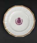 DOM PEDRO II  SERVIÇO DA COROA ROXA  DE USO HABITUAL NO PAÇO DE SÃO CRISTÓVÁO. O ANUÁRIO DO MUSEU IMPERIAL DE PETRÓPOLIS PUBLICADO EM 1942 E QUE TRATA SOBRE AS PORCELANAS DAS LOUÇAS IMPERIAIS TRAZ SOBRE ESSE SERVIÇO DE JANTAR AS SEGUINTES INFORMAÇÕES: SERVIÇO POLIGONAL, COM FRISOS DOURADOS E AS ARMAS IMPERIAIS EM ESMALTE ROXO. APARELHO HABITUAL DO PALÁCIO DE S. CRISTÓVÃO. NÃO FOI POSSÍVEL IDENTIFICÁ-LO NO CATÁLOGO DO LEILÃO DE S. CRISTÓVÃO, MAS EXISTE UMA REFERÊNCIA A ELE NO O PAÍS, DE 25 DE JULHO DE 1890. O PRATO É DECORADO COM FRISO DOURADO, BORDA RECORDADA  EM POLIGONOS QUE SE ESTENDEM ATÉ O INICIO DA CALDEIRA.  NO CENTRO DA CALDEIRA, BRASÃO DO IMPÉRIO DO BRASIL EM ROXO. CURIOSO NOTAR QUE A COROA QUE ENCIMA O BRASÃO É SIMILAR A COROA DO IMPÉRIO RUSSO OU DO IMPÉRIO GERMANICO. DREYFUS REPRODUZ ESSE PRATO NA PÁGINA 215 DO LIVRO "LOUÇA DA ARISTOCRACIA NO BRASIL, POR JENNY DREYFUS". ESSE AUTOR CLASSIFICA A ORIGEM DA LOUÇA COMO PROVAVELMENTE INGLESA.  A FORMA DA COROA, O TIPO DA LOUÇA E A AUSÊNCIA DE MARCA DE FABRICANTE (IMPESSÁVEL PARA OS  INGLESES PRINCIPALMENTE EM UM SERVIÇO DE ENCOMENDA IMPERIAL) NOS FAZ DIVERGIR DA OPINIÃO DESSE AUTOR ACREDITAMOS  QUE A ORIGEM DO PRATO É GERMÂNICA. SOBRE ESSE SERVIÇO HÁ UMA OUTRA CURIOSIDADE: CONTA-SE QUE EM CERTA OCASIÃO O CONDE DEU ENTROU NA COZINHA DO PAÇO DE SÃO CRISTÓVÃO E SURPREENDEU OS EMPREGADOS FAZENDO A REFEIÇÃO COM PRATOS DESSE SERVIÇO. O CONDE IMEDIATAMENTE MANDOU RECOLHER A LOUÇA E PROIBIU SEU USO. O AUTOR DESSE RELATO ATRIBUI A ATITUDE DO CONDE A UM CORPORTAMENTO RANHETA OU MUQUIRANA MAS OUTRA NÃO PODERIA SER A ATITUDE DE UM HERDEIRO DOS REIS DA FRANÇA, UMA CORTE DE POMPA E APEGADA AOS SÍMBOLOS DE SUA NOBREZA QUE CONTRASTAVA COM A MONARQUIA BURQUEZA E PALPÉRRIMA DO BRASIL.    EUROPA, SEC. XIX. 23 CM DE DIAMETRO.NOTA: A Regência comprou louças de porcelana para o sr. dom Pedro II, e este, logo após sua maioridade, efetuou várias e maiores compras. De 1839 a 1843 acham-se nos livros de mordomia referências a louças. Vejamos os registros: Em 1839: M. J. de Araújo Costa  Um aparelho de louça superfina 206$100 Em 1840: A Wallerstein, custo de pratos de porcelana 50$000 A B. Wallerstein, 70 dúzias de pratos de porcelana vindos da França 592$099 A Saturnino José Gonçalves, louça ordinária 39$600 Em 1841: 5. Há mais as seguintes indicações, no arquivo do castelo dEu. Dom João VI  Relação das salas que há no Real Paço Velho. Relação de jóias, prata, móveis etc., pertencentes à duquesa de Bragança e aos filhos de d. Pedro I  25 páginas de texto. Contas da Casa imperial do Brasil em 23 de maio de 1889. 183 Anuário do Museu Imperial A Demarais, 51 xícaras de porcelana 50$000 A Saturnino José Gonçalves, louça ordinária e de vidros que forneceu nos meses de novembro de 1840 a setem- bro de 1841 854$5  A Adolfo Simonsi, direitos na alfândega de louça e livros vindos de Londres 192$500 A Bernardo Wallterstein e Cia., por quinhentos e dezesseis pratos de porcelana fina 5:132$736 A Bernardo Wallerstein, por nove dúzias e quatro casais de xícaras de porcelana fina dourada 373$330 A Luís Antônio de Faria, por cinco dúzias de xícaras e pires 180$000 Em 1842: A Wallerstein, louça de porcelana fixa 927$000 A B. Wallerstein, por quatro caixas com louça de porcelana fina 4:848$000 Em 1843: Custo de xícaras e pires de porcelana 314$664. Em apenas  quatro anos, e numa época em que a capacidade aquisitiva de nossa moeda era muito grande, foram gastos 16:829$400 em compras de serviços de porcelana, para uso de Suas Majestades. Catálogo dos leilões do Paço de São Cristóvão Se, de 1843 em diante, não são encontradas nos Livros da Mordomia menções a compras de louça, fácil será avaliar-se o volume e a qualidade das porcelanas, não só pela impressionante amostra das que foram adquiridas no início do Segundo Reinado (1840 a 1843), como pelas existentes nos paços, por ocasião dos leilões de 1890.