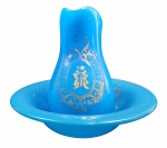 VISCONDE DE MAUÁ  IRINEU EVANGELISTA DE SOUSA (18131889) -  BACCARAT - REQUINTADO GOMIL E BACIA EM OPALINA AZUL CELESTE DA MANUFATURA DE BACCARAT -  DECORADO A OURO COM GUIRLANDAS EMOLDURANDO MONOGRAMA "BM" SOB COROA DE BARÃO COM GRANDEZA. PERTENCEU A  IRINEU EVANGELISTA DE SOUSA O VISCONDE DE MAUÁ (AINDA COMO BARÃO). O MUSEU HISTÓRICO NACIONAL CONSERVA EM SEU ACERVO UMA CAVE EM BRONZE DOURADO COM CRISTAL CONTENDO MONOGRAMA IDENTICO A ESTE. ESTA PEÇA ESTÁ REPRODUZIDA NO LIVRO O CRISTAL NO IMPÉRIO DO BRASIL POR JORGE GETULIO VEIGA ET ALL PAG 219 (VIDE FOTO NOS CRÉDITOS EXTRAS DESSE LOTE). FRANÇA, SEGUNDA METADE DO SEC. XIX. 40 CM DE DIAMETRO (BACIA)NOTA: Irineu Evangelista de Sousa acumulou histórias fascinantes ao longo de sua icônica e revolucionária trajetória no Brasil Império.  No auge de sua carreira, em 1867, os ativos de suas empresas somavam 115 mil contos de réis. O orçamento anual de todo o Império do Brasil era de apenas 97 mil contos de réis.  Mauá controlava sozinho 17 empresas espalhadas por 6 países: Brasil, Uruguai, Argentina, Inglaterra, França e Estados Unidos.  Nascido no Rio Grande do Sul, ele perdeu o pai na infância e foi enviado sozinho ao Rio de Janeiro com apenas 9 anos de idade. Ele começou trabalhando como caixeiro e limpando estantes em uma loja de tecidos. Devido à sua facilidade com matemática, contabilidade e caligrafia, ele passou a gerenciar a tesouraria da empresa e a guardar as chaves do cofre principal com apenas 14 anos. Tinha uma relação tensa com Dom Pedro II. O Imperador Dom Pedro II era um homem focado na erudição, nas artes e na estabilidade agrária. Ele tinha profundas desconfianças do capitalismo acelerado, do dinamismo de Mauá e do surgimento de uma nova elite burguesa industrial. O título de "Barão de Mauá" foi concedido por Dom Pedro II em 1854, no dia da inauguração da primeira ferrovia do país. Contudo, historiadores apontam que as honrarias eram uma forma do governo reconhecer o feito técnico sem precisar dar o apoio financeiro e político que Mauá tanto pedia para suas indústrias.  Mauá não era apenas um abolicionista teórico. Ele comprava e alforriava escravizados para que trabalhassem como assalariados em suas indústrias, além de dar abrigo secreto a foragidos. Sua postura firme contra a escravidão gerou ódio entre os barões do café e latifundiários. Como retaliação, seu estaleiro em Niterói (o Ponta de Areia) sofreu atentados e incêndios criminosos misteriosos que destruíram maquinários caríssimos. Durante as crises financeiras e políticas no Uruguai, o Banco Mauá financiou diretamente o governo de Montevidéu. Mauá chegou a ser o maior credor do país vizinho, possuindo tanta influência que a economia uruguaia dependia quase inteiramente de suas decisões bancárias.  Seguindo um costume comum entre as elites da época para manter o patrimônio protegido, Irineu casou-se com sua própria sobrinha, Maria Joaquina de Sousa Machado. A locomotiva da primeira ferrovia brasileira foi batizada como "Baronesa" em homenagem a ela. Em 1849, o estaleiro de Mauá construiu o maior e mais rápido navio mercante do Brasil, batizado de Serpente. Devido à velocidade da embarcação, ela acabou sendo comprada clandestinamente e utilizada por traficantes de escravizados para burlar a fiscalização britânica no oceano. Isso gerou um enorme incômodo para Mauá, que era um abolicionista declarado.