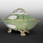 1º BARÃO DE ITAMBÉ FRANCISCO JOSÉ TEIXEIRA (1780-1866)  PRINCIPESCA TERRINE PERTENCENTE AO SERVIÇO DO BARÃO DE ITAMBÉ. A TRAVESSA QUE LHE SERVE COMO PRESENTOIR SERÁ APRESENTADA NO LOTE A SEGUIR. ESTE CONJUNTO FORMADO PELO LOTE ATUAL E O PRÓXIMO É IDENTICO AO APRESENTADO NOS DOIS LOTES ANTERIORES.  MANUFATURA EM PORCELANA DE PARIS. BORDA VERDE COM "VERMICULATED GROUND" REMATADO EM OURO. NA TAMPA E NO CORPO  RESERVAS ENRIQUECIDAS COM MOTIVOS FLORAIS EM OURO, CONTENDO OS DIZERES: "B. DE ITAMBÉ".A TAMPA TEM ESPETAULAR PEGA DUPLA TRANÇADA QUE SE ERGUE MAJESTOSAMENTE SOBRE O CONJUNTO. ELEVADA SOBRE QUATRO FORMIDÁVEIS PÉS REMATADOS EM OURO. REPRODUZIDO NO LIVRO "LOUÇA DA ARISTOCRACIA NO BRASIL" POR JENNY DREYFUS NA PAG. 275, SEM MARCA. FRANÇA. SÉCULO XIX. 32 CM DE DIAMETRO.