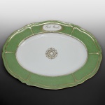1º BARÃO DE ITAMBÉ FRANCISCO JOSÉ TEIXEIRA GRANDE E MAGNÍFICA TRAVESSA EM PORCELANA DE PARIS COM SUNTUOSA DECORAÇÃO EM "VERMICULATED GROUND" REMATADO EM OURO. É O PRESENTOIR DA LEGUMEIRA APREGOADA NO LOTE ANTERIOR E IDENTICO AO CONJUNTO APRESENTADO NOS DOIS LOTES ANTERIORES. A TITULO DE REFERÊNCIA APRESENTAREMOS NO ÚLTIMO LOTE DESSE LOTE A FOTOGRAFIA DA LEGUMEIRA SOBRE O PREENTOIR. BORDA VERDE COM "VERMICULATED GROUND" REMATADO EM OURO. NA PARTE SUPERIOR, RESERVA ENRIQUECIDA COM MOTIVOS FLORAIS EM OURO, CONTENDO OS DIZERES: "B. DE ITAMBÉ". AO CENTRO ROSÁCEA DOURADA. PASTA DURA. REPRODUZIDO NO LIVRO "LOUÇA DA ARISTOCRACIA NO BRASIL" POR JENNY DREYFUS NA PAG. 275, SEM MARCA. FRANÇA. SÉCULO XIX. 46 CM DE DIÂMETRO FRANÇA, SEC. XIX. 33 CM DE COMPRIMENTO.