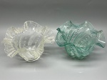 Par de cúpulas em demi cristal translúcido, nas cores incolor e verde, com decoração em relevo e borda ondulada, medidas 11x5x15 cm. Apresenta marcas do tempo, uso e bicados.
