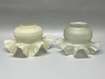 Par de cúpulas semelhantes em demi cristal satinê, com decoração em relevo de gomos torcidos, pontilhados e borda ondulada plissada, medidas 9x4,5x15,5 cm e 9x5,5x14,5 cm. Apresenta marcas do tempo, uso e bicados.