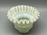 Cúpula antiga em opalina, corpo escalonado em dois níveis com textura de gomos relevados. Borda superior em formato de saia amplamente expandida com acabamento ondulado e plissado. Medidas: 10x5,5x13 cm. Apresenta marcas do tempo, de uso e bicados.