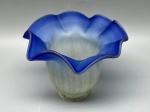 Cúpula antiga em demi cristal satinê jateado, corpo moldado com gomos verticais suaves em tom esbranquiçado. Apresenta transição para uma ampla saia expandida com acabamento ondulado em tom azul-escuro. Medidas: 12x5,5x15 cm. Apresenta marcas do tempo, de uso e bicados.