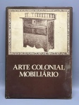 ARTE COLONIAL BRASILEIRA  MOBILIÁRIO. Editora das Américas / Edameris. Importante obra de referência dedicada ao estudo do mobiliário do período colonial brasileiro, apresentando peças históricas como arcazes, armários policromados e poltronas entalhadas em jacarandá e cedro. Capa dura original com sobrecapa; a sobrecapa apresenta marcas de tempo, leves desgastes e sujidades nas extremidades e na parte traseira; miolo e páginas internas muito bem preservados e limpos, com reproduções fotográficas nítidas.
