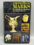 ANTIGUIDADES E REFERÊNCIA  A DICTIONARY OF MARKS. The Identification Handbook for Antique Collectors, editado por Margaret Macdonald-Taylor. Publicado por The Connoisseur. Prático e conceituado manual de bolso voltado à identificação de marcas, assinaturas e contrastes em peças de cerâmica, prataria e metais, tapeçaria e mobiliário de diferentes períodos históricos. Essencial para colecionadores, antiquários e peritos de arte. Encadernação rígida com sobrecapa original ilustrada; leves marcas de manuseio e desgaste nas extremidades da sobrecapa