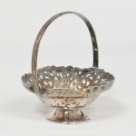 METAL PRATEADO, uma (1) mini fruteira no formato de cesta, borda vazada em elementos vegetalistas, alça relevada em elementos vegetalistas, base cônica, marca MERIDIONAL, medindo 9 cm altura e 8 cm diâmetro, sinais de uso, vide foto.