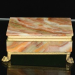 DIVERSOS, uma (1) caixa porta joias, confeccionada com placas em ônix, monture em metal dourado, pés com terminações em garras, tampa com abertura basculante, medindo 13,5 x 9,5 x 5,5 cm, sinais de uso, vide foto.