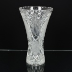CRISTAL, um (1) vaso floreiro, grosso, incolor e translúcido, lapidado em sulcos, flores e bico de jaca, fundo estrelado, boca no formato de corneto, medindo 30 cm altura e 17 cm diâmetro, vide foto.