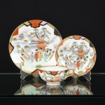 PORCELANA JAPONESA, um (1) trio para chá (xícara, pires e pratinho de bolo), padrão Kutani, ornamentação pintada a mão em policromia com paisagem lacustre, gueixas, pagode, ponte, pássaros, montanhas e elementos vegetalistas, arremates a ouro, medindo a maior peça 18,5 cm diâmetro, com as seguintes marcas: prato de bolo com marcas em caracteres do fabricante; o pires a expressão em caracteres DAI NI PON (grande Japão) além da legenda Made in Japan; a xícara a legenda de origem Made in Japan, ideal para coleção de cristaleira, vide foto.