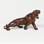 ESCULTURA, uma (1) animalista representando tigre, entalhada em raiz de roseira, olhos de vidro, dentes em marfim ou osso, medindo 29 cm comprimento, sinais de uso, vide foto.
