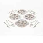 AÇO INOX, um (1) conjunto para degustação de escargot com doze itens: 4 garfos; 4 prendedores e 4 pratos, marcas APOLLONOX e UGINOX, para quatro pessoas, medindo a maior peça 13 cm diâmetro, não aparentam terem sido usados, vide foto.