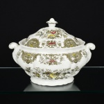 FAIANÇA INGLESA, uma (1) sopeira com tampa, modelo WINDSOR, marca RIDGWAY (Ralph Ridgway 1726 a ? primeiro oleiro da família teve 3 filhos mas somente dois seguiram a mesma profissão do pai, são eles: George Ridgway 1757 a 1823 e Job Ridgway 1759 a 1814 que trabalharam juntos na Bell Works entre 1782 e 1802, quando se separaram George permaneceu na empresa e Job abriu a Cauldon Place 1802 a 1808, em 1806 os irmãos trabalharam novamente em parceria na Bellevue Pottery, em 1808 Job uniu a Bell Works e Cauldon Place e a razão social passou a ser Job Ridgway & Sons 1808 a 1814, em 1814 com a morte de Job a empresa ficou para seus 2 filhos John Ridgway 1785 a 1860 e William Ridgway 1788 a 1864, a razão social mudou para John & William Ridgway 1814 a 1830, em 1830 os irmãos se separaram William ficou com a Bell Works {por conta própria, mas também com seu filho Edward John Ridgway 1814 a 1896 e outros parceiros chegou a controlar 6 olarias, aposentou-se em 1854, seu filho continuou parte dos negócios, em 1866 mudou-se para Shelton, em 1870 colocou os filhos na sociedade, em 1872 aposentou-se, seus filhos John & Edward Ackroyd Rigdway continuaram os negócios, posteriormente juntaram-se a Joseph Sparks, em 1955 virou subsidiária da Allied English Potteries, atualmente é subsidiária da Royal Dolton Tablewares Ltd} e John ficou com a Cauldon Place, {John Ridgway & Co 1830 a 1855; John Ridgway, Bates & Co 1856 a 1858; Bates, Brown-Westhead & Co 1858 a 1862; Brown-Westhead Moore & Co 1862 a 1962, fechou), ornamentação floral policromada, medindo 25,5 cm diâmetro mais as alças, vide foto.