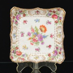 PORCELANA INGLESA, um (1) covilhete quadrangular, borda recortada e canelada, ornamentação floral policromada, arremates a ouro, marca HAMMERSLEY (fundada em 1862 como Adams, Scrivener & Co.; alguns anos depois virou Harvey Adams & Co.; em 1885 virou Hammersley & Co.; em 1932 virou Harmmersley and Company (Longton) Ltd.), modelo DRESDEN SPRAYS, medindo 13,5 x 13,5 x 3 cm, sinais de uso, vide foto.