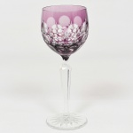 CRISTAL OVERLAY, uma (1) taça de pé alto para vinho, translúcida, bojo roxo sobre incolor, lapidado em estrelas e esferas, fuste com facetado hexagonal e base em bolacha com fundo estrelado, ambos incolores, medindo 19 cm altura, vide foto.
