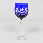 CRISTAL OVERLAY, uma (1) taça de pé alto para vinho, translúcida, bojo azul sobre incolor, lapidado em estrelas e esferas, fuste com facetado hexagonal e base em bolacha com fundo estrelado, ambos incolores, medindo 19 cm altura, vide foto.