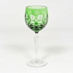 CRISTAL OVERLAY, uma (1) taça de pé alto para vinho, translúcida, bojo verde sobre incolor, lapidado em estrelas e esferas, fuste com facetado hexagonal e base em bolacha com fundo estrelado, ambos incolores, medindo 19 cm altura, vide foto.